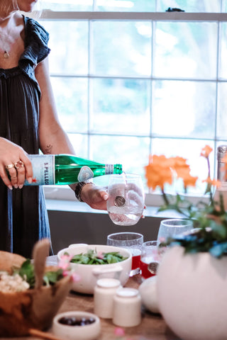 Woman pouring red wine into a glass.