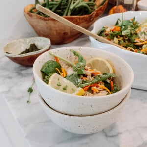 A bowl of food on a counter with a wooden spoon, ready to be served.