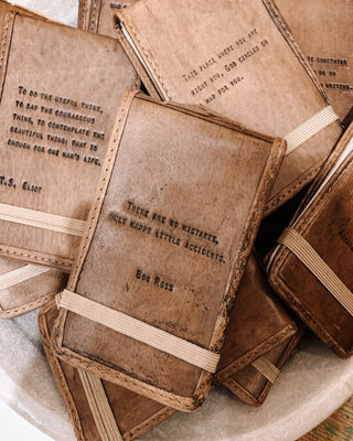 A bowl filled with leather books and a note, creating a captivating display of knowledge and intrigue.